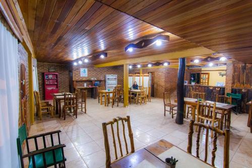 een restaurant met houten plafonds en tafels en stoelen bij Posada Los Tajibos in Puerto Iguazú