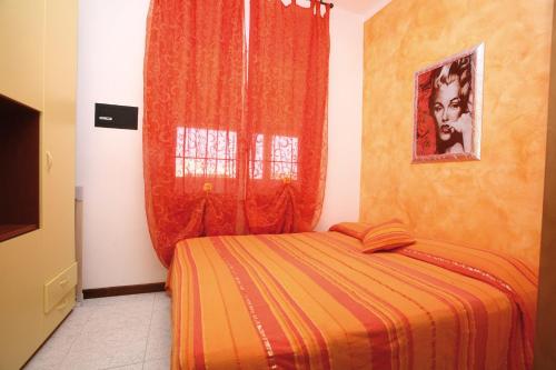ビビオーネにあるFrancoのベッドルーム1室(オレンジの毛布、窓付)