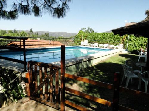 una piscina junto a una valla con una valla en X Sierras Cabañas en Villa Carlos Paz