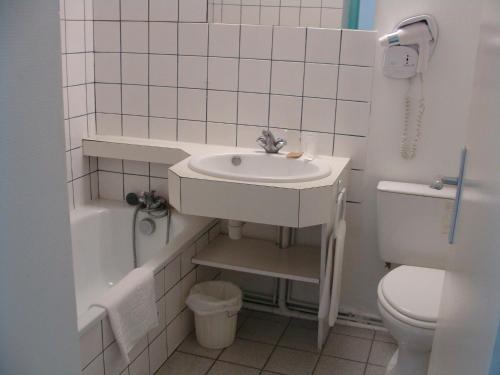 a white bathroom with a sink and a toilet at HOTEL RESTAURANT CIRIUS in Montrond-les-Bains