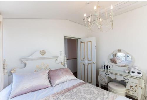 a bedroom with a white bed and a chandelier at HANI Haus in Jeju