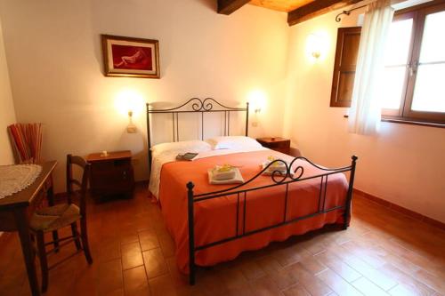 een slaapkamer met een bed, een tafel en een stoel bij Appartamento TRE QUERCE di Guerrini Patrizia in Sorano