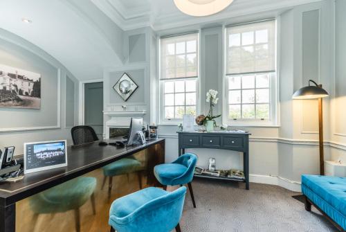 an office with a desk and blue chairs at Gorse Hill Hotel in Woking