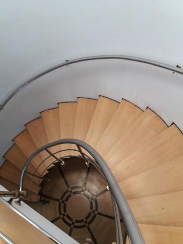 a wooden spiral staircase with a white ceiling at Green Wood Apartament Stara Ochota in Warsaw