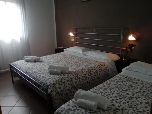 a bedroom with two beds with towels on them at Fasthotel in Cervia