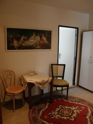 a living room with two chairs and a table and a painting at Apartments Meixner in Mariánské Lázně