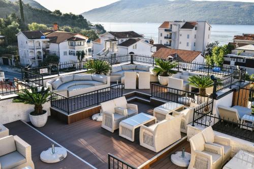 an apartment balcony with chairs and a view of a city at Wellness & Spa Hotel ACD in Herceg-Novi