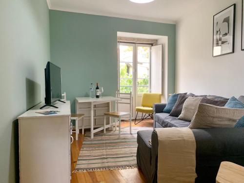 a living room with a couch and a tv at Apartments Center Castelo de São Jorge in Lisbon
