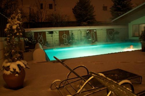 a swimming pool at night with snow on the ground at Penzion Diana in Piešťany