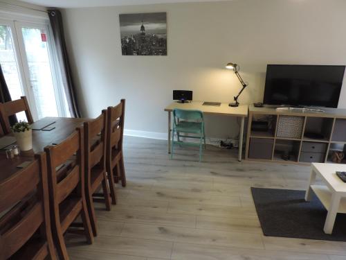 a living room with a table and a desk with a television at 5 Bed Camberley Airport Accommodation in Camberley