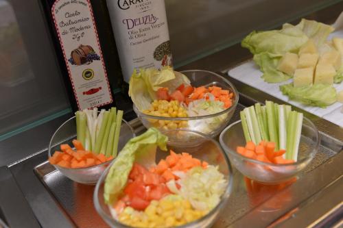four bowls filled with vegetables on a counter at Santa Croce Boutique Hotel in Venice
