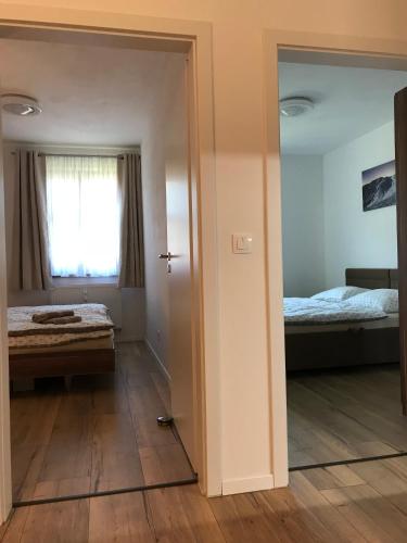 a room with a bedroom with a bed and a mirror at Apartmán B3 Biela Púť - Jasná in Belá