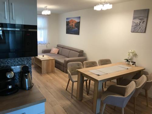 a living room with a table and a couch at Apartmán B3 Biela Púť - Jasná in Demanovska Dolina