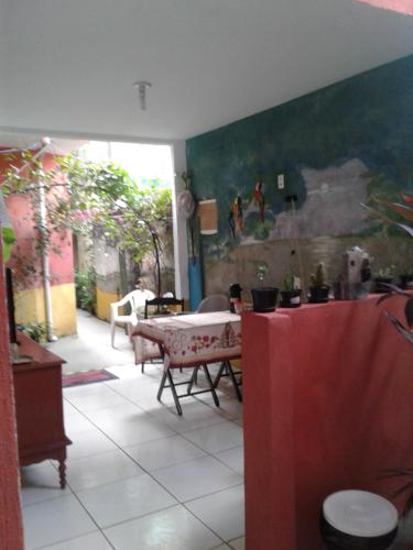 a living room with a table and a dining room at Pousada da Didi in Belém