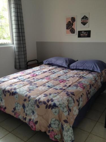 a bed with a comforter and pillows in a bedroom at Apartamento Vila do Sol in Blumenau