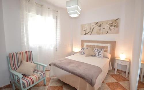 コニル・デ・ラ・フロンテーラにあるApartamento Anita Conilのベッドルーム1室(ベッド1台、椅子付)