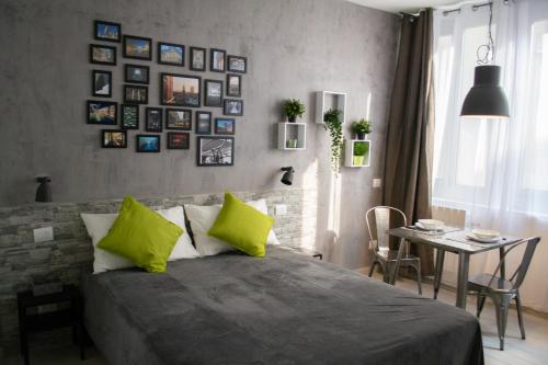 a bedroom with a bed with green pillows and a table at Warrest - Short Rent Apartments in Milan