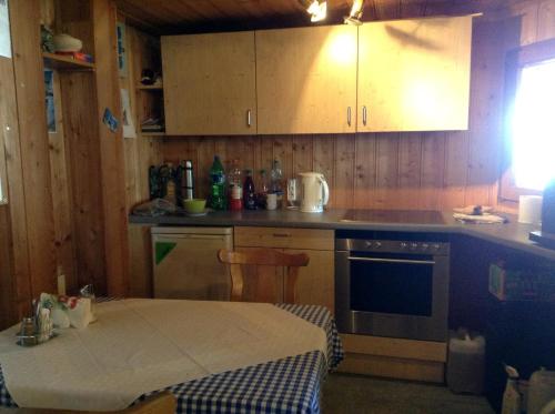 eine Küche mit einem Tisch, einem Herd und Schränken in der Unterkunft Ferienhof Kriechbaumer in Schönau im Mühlkreis