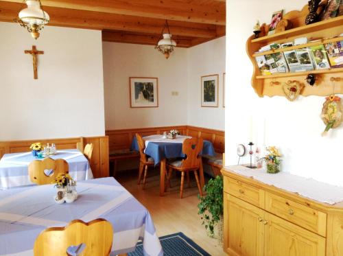 un restaurante con dos mesas y una cruz en la pared en Ferienhof Kriechbaumer, en Schönau im Mühlkreis