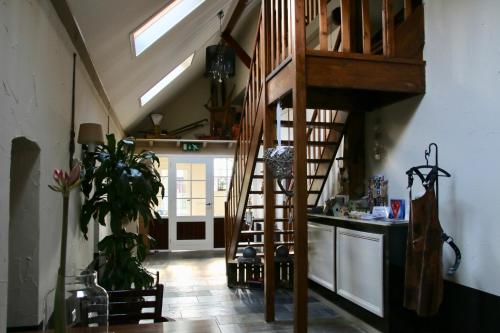 a living room with a spiral staircase in a house at Gastenverblijf Eenink in Zelhem