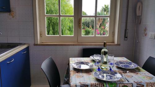 a table with a bottle of wine and glasses on it at Anastasia Villas-B&B in Lido Signorino