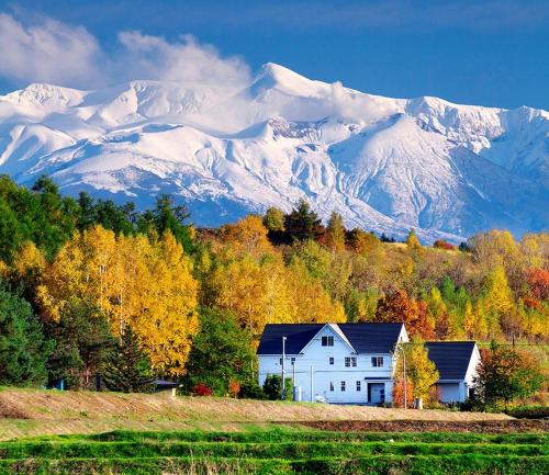 a white house in front of a snow covered mountain at Asahikawa - house / Vacation STAY 5789 in Higashikagura