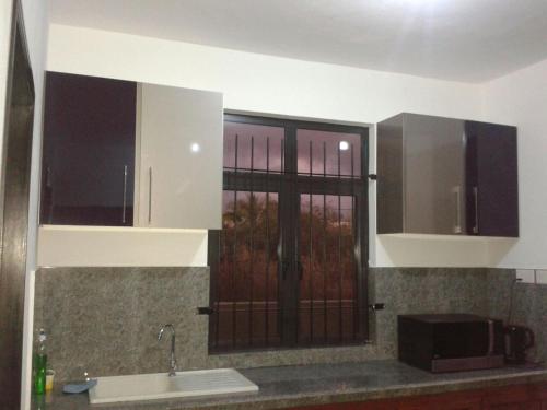 a kitchen with a sink and a microwave at Happy Villa in Trou aux Biches