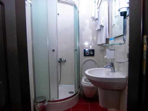 een badkamer met een douche, een toilet en een wastafel bij Hotel Timya in Istanbul