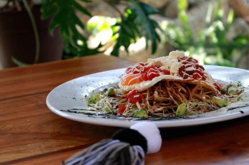 een bord spaghetti op een houten tafel bij Hotel Bosques del Sol Suites in San Cristóbal de Las Casas