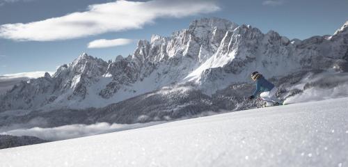 a person is skiing down a snow covered mountain at Loewe Dolomites in San Candido