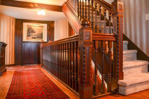 a spiral staircase in a home with a red rug at The Towers Bed & Breakfast in Milford