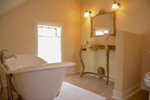 a bathroom with a tub and a sink and a mirror at The Towers Bed & Breakfast in Milford