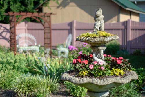 a stone bird bath with a statue in a garden at The Towers Bed & Breakfast in Milford