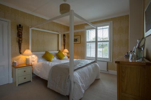 チェルトナムにあるNumber 8 Cheltenhamのベッドルーム(天蓋付き白いベッド1台付)