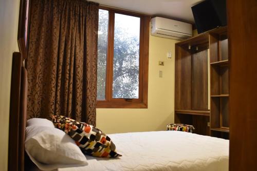 1 dormitorio con cama y ventana en Hotel Bonanza, en Guayaquil