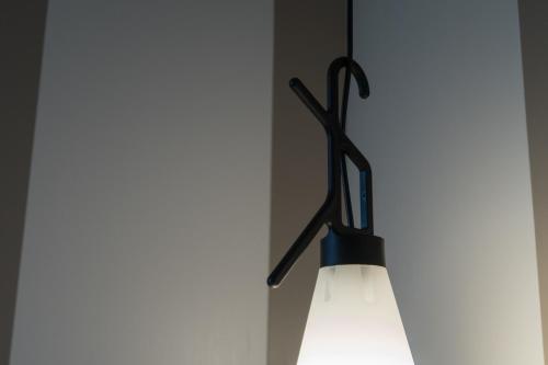 a light with a pair of scissors hanging on a wall at Hotel San Giovanni Roma in Rome