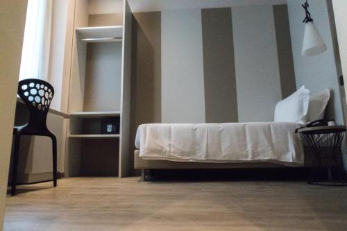 a bedroom with a bed and a chair and a mirror at Hotel San Giovanni Roma in Rome