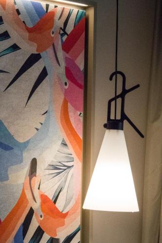 a light hanging from a wall next to a painting at Hotel San Giovanni Roma in Rome