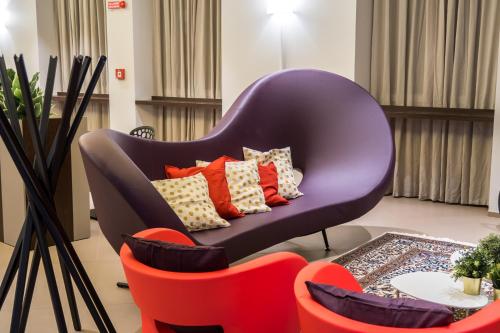 a purple chair with colorful pillows in a living room at Hotel San Giovanni Roma in Rome