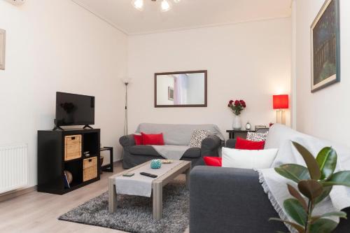 - un salon avec deux canapés et une télévision dans l'établissement City Center Apartment near HELEXPO, à Thessalonique