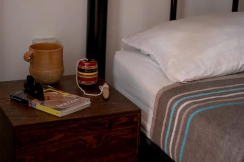 a bedroom with a bed and a nightstand with a table with a nightstand at Hostel Hospedarte Centro in Guadalajara