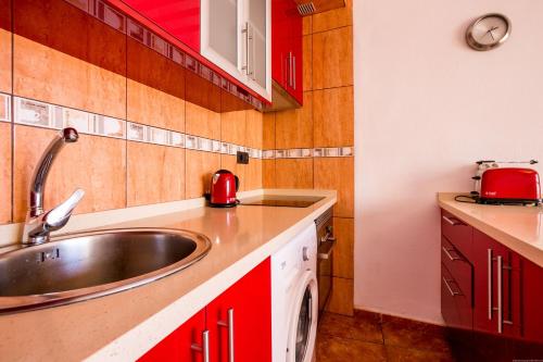 a kitchen with a sink and red cabinets at Orlando 85 in Adeje