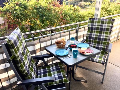 einen Tisch und zwei Stühle mit Essen auf dem Balkon in der Unterkunft Fewo Mittelmole in Warnemünde