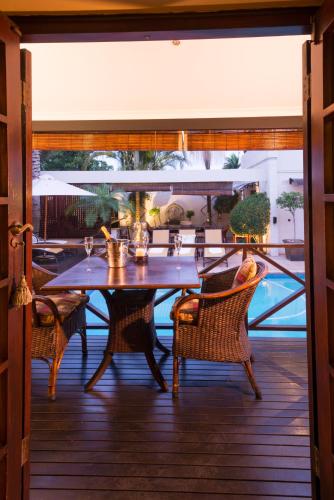 a table and chairs sitting on a deck with a table and chairs at Five Burnham Guest House in Durban
