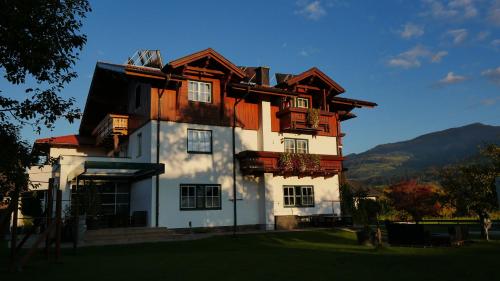 a large white building with a gambrel roof at Gästehaus Hartweger in Haus im Ennstal
