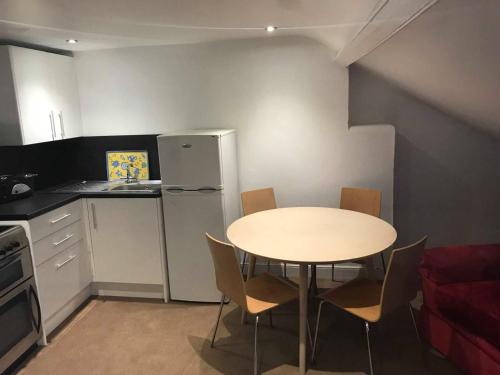 a small kitchen with a table and a refrigerator at No 47 Marine Terrace in Aberystwyth