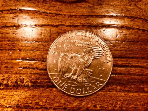 a dollar coin sitting on top of a wooden table at Lantern Hotel in Hohhot