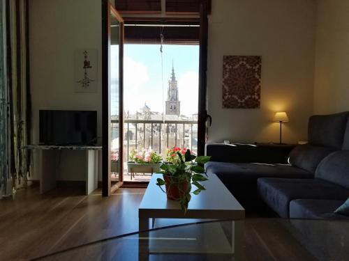 ein Wohnzimmer mit einem Sofa und Blick auf ein Gebäude in der Unterkunft Apartamento PRANA Junto al Alcázar in Toledo