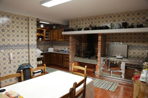 a kitchen with a table and a brick fireplace at Casa do Lavrador in Casal