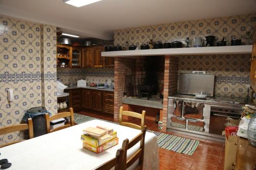 a kitchen with a table and a stove top oven at Casa do Lavrador in Casal